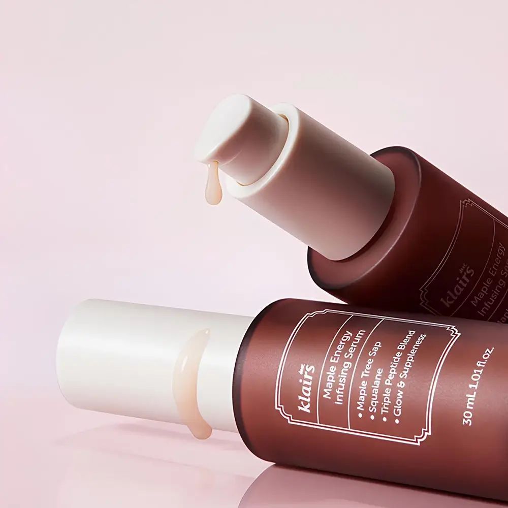 Zwei braune Flaschen mit weißen Deckeln. Serum tropft aus einer Flasche. Aufschrift: klairs.