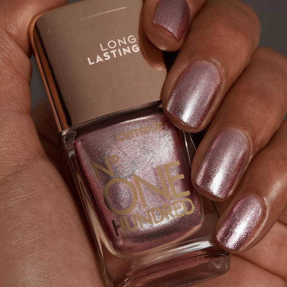 Nagellackflasche mit rosa-metallischem Inhalt. Aufgetragen auf Fingernägeln. Auf der Flasche steht 'LONG LASTING' und 'ONE HUNDRED'.