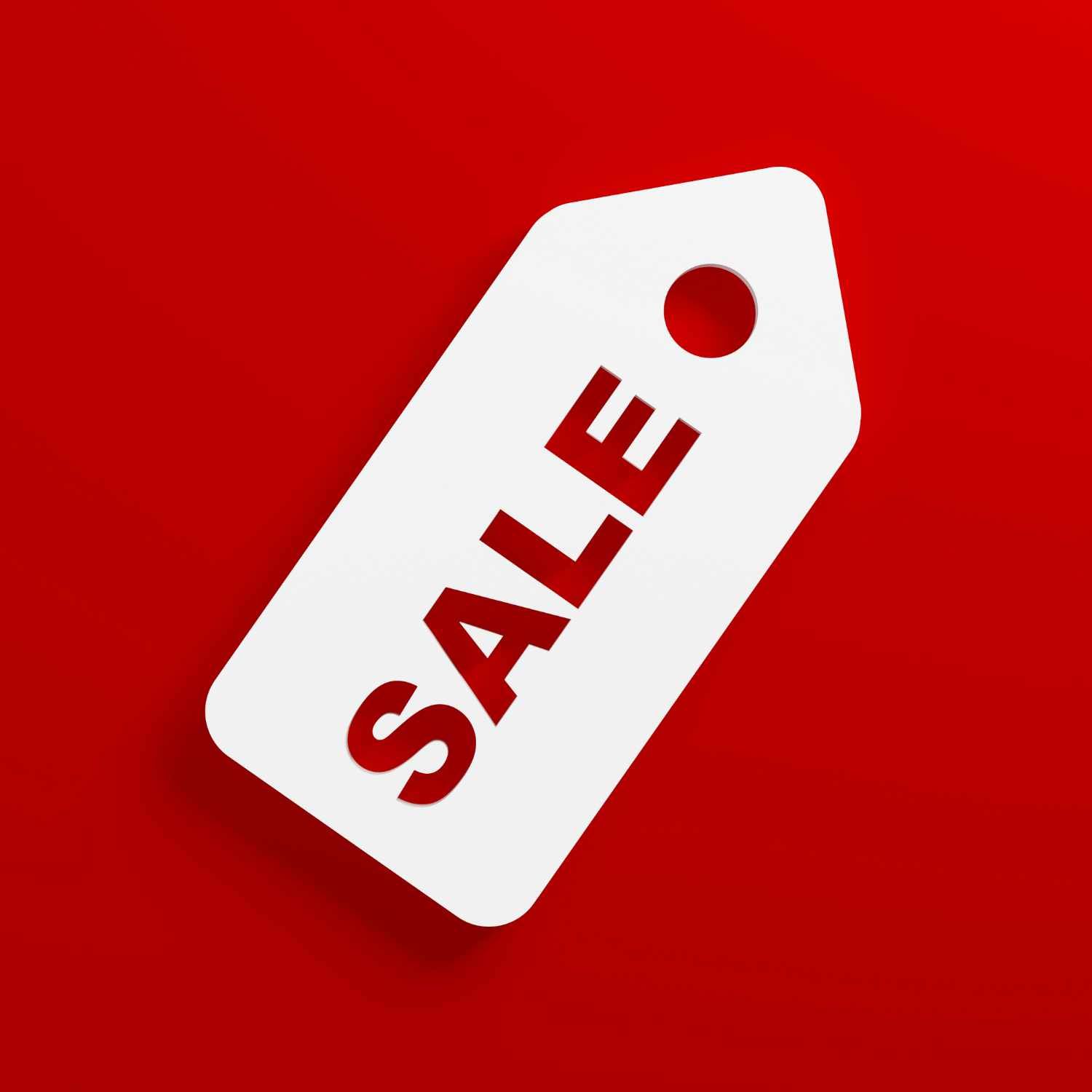 Weißes Preisschild mit rotem "SALE"-Schriftzug auf rotem Hintergrund.