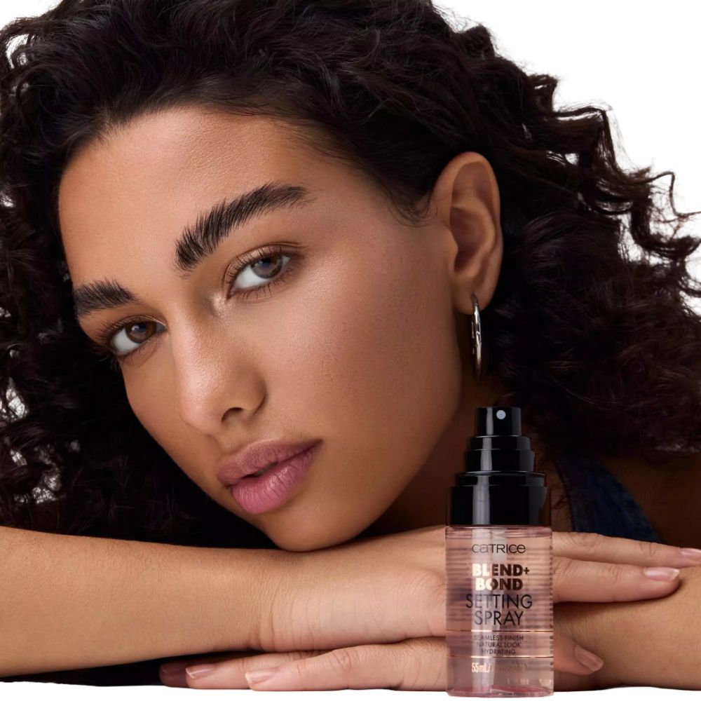 Frau mit Catrice Blend + Bond Setting Spray. Transparente Flasche mit schwarzem Sprühkopf. Schriftzug: Blend + Bond, Setting Spray.