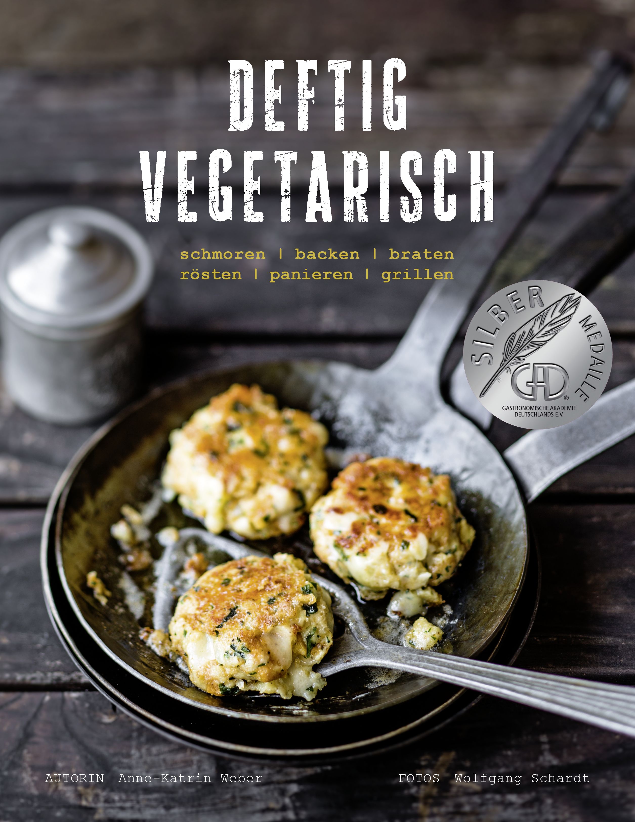Kochbuch "Deftig Vegetarisch" mit vegetarischen Gerichten. Auf dem Cover: Pfanne mit Bratlingen, Silbermedaille.