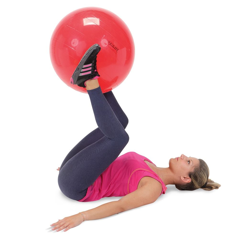 Eine Frau liegt auf dem Rücken und hält einen roten Gymnastikball zwischen ihren Füßen.