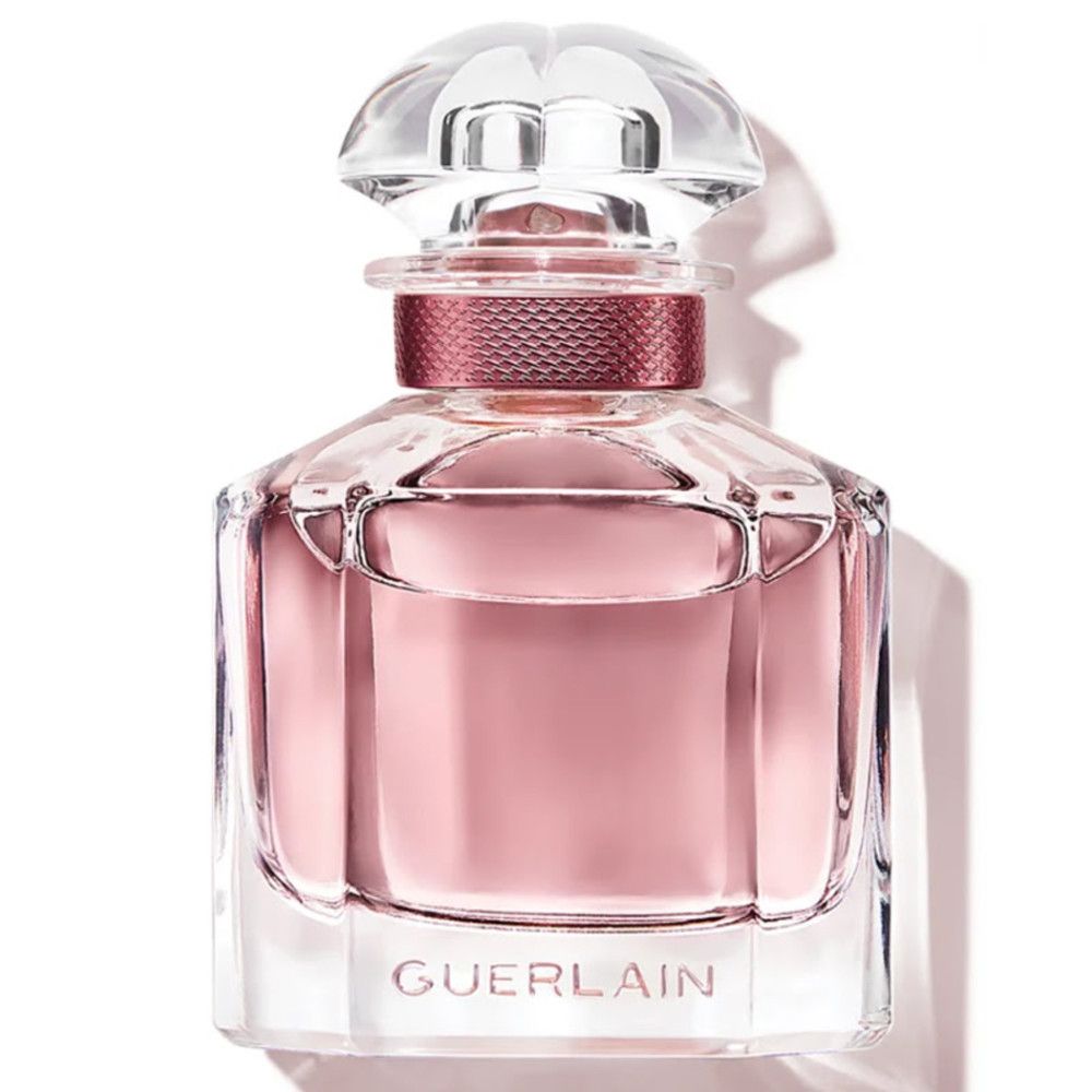 Flakon mit rosafarbenem Inhalt. Aufschrift: Guerlain. Transparenter Verschluss.
