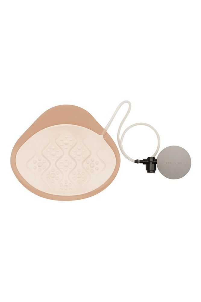 Brustepithese mit Zubehör. Beige, tropfenförmig. Mit Pumpe und Schlauch. Graue Kugel. Innenseite mit Muster.