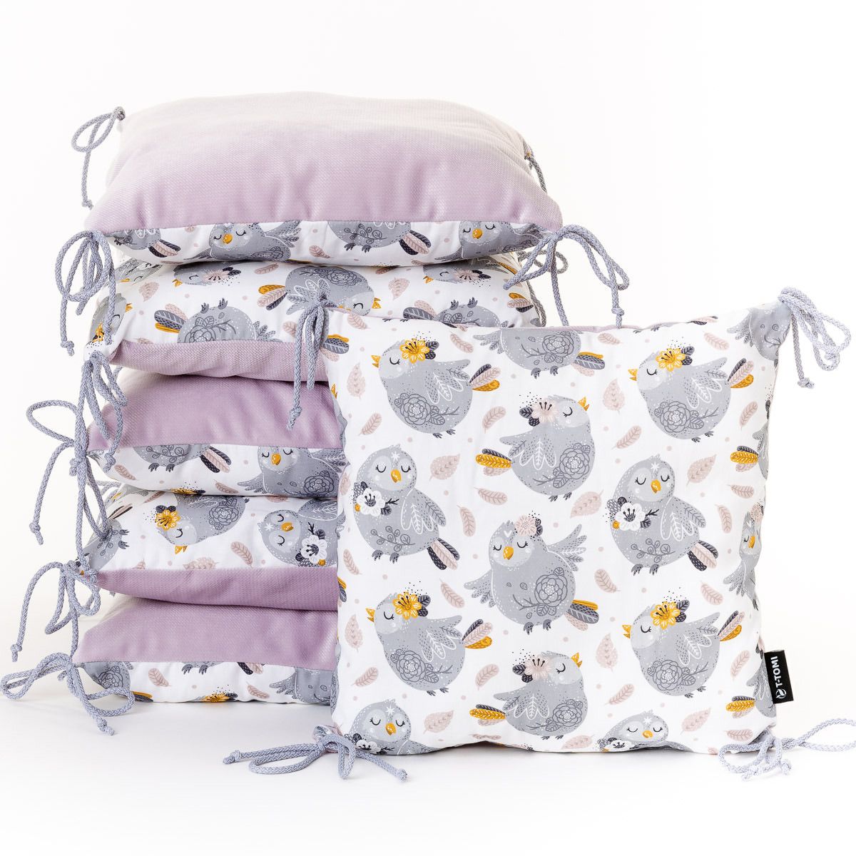 Stapel von Sitzkissen mit Vogelmotiv und lila Samt.