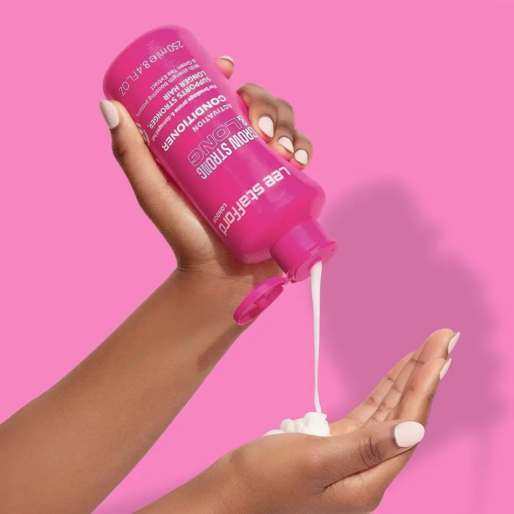 Rosa Flasche, Conditioner, Produkt wird in die Hand gegossen. Text: Grow Strong & Long, Lee Stafford.