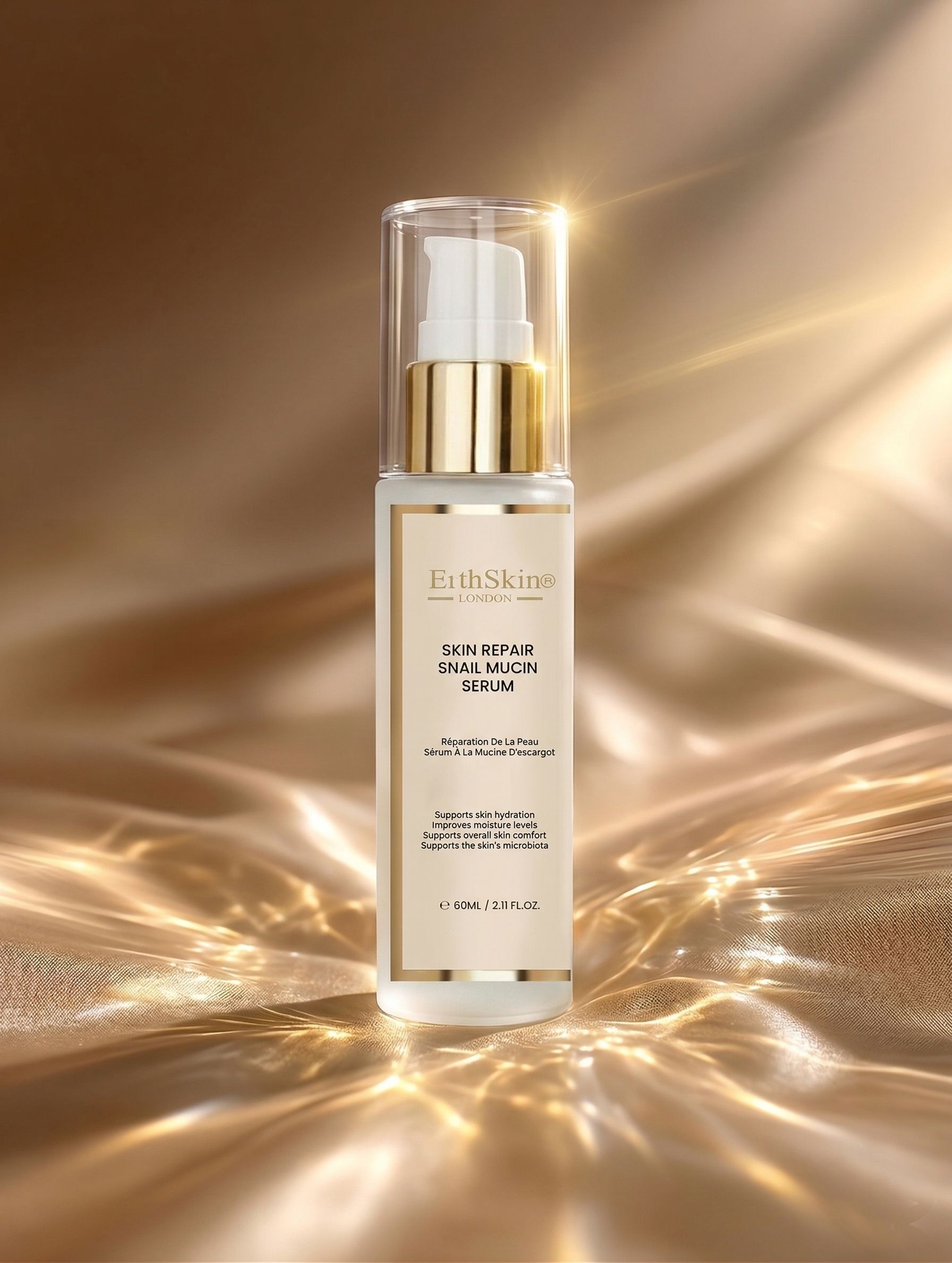 Flasche mit Pumpspender für Hautreparatur-Schneckenschleim-Serum, auf glänzendem goldenen Stoff.