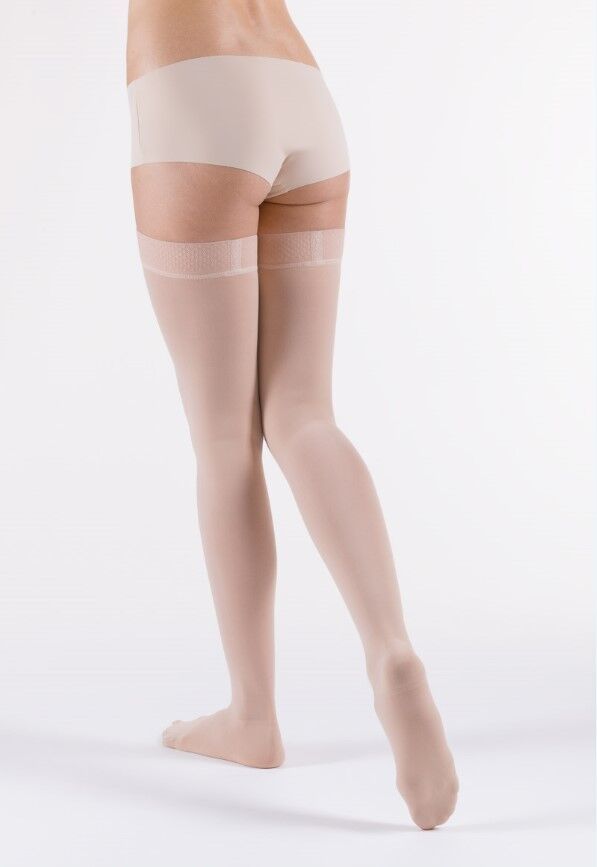 Rückansicht einer Person, die hautfarbene Kompressionsstrümpfe trägt. Strümpfe reichen bis zum Oberschenkel.