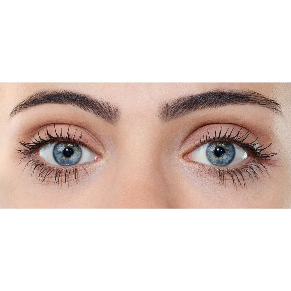 Nahaufnahme von zwei blauen Augen mit getuschten Wimpern. Die Augenbrauen sind natürlich geformt.