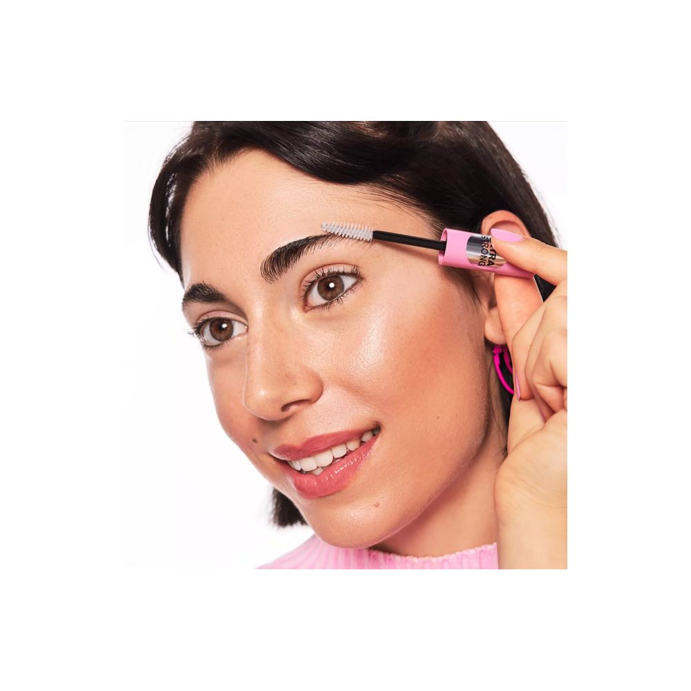 Frau mit Augenbrauengel-Applikator. Rosa Tube, schwarze Bürste. Produktanwendung.