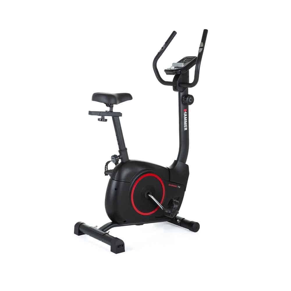 Schwarzes Heimtrainer-Fahrrad mit rotem Akzent. Sichtbar sind Sattel, Lenker, Pedale und ein Display. Das Logo "Hammer" ist sichtbar.