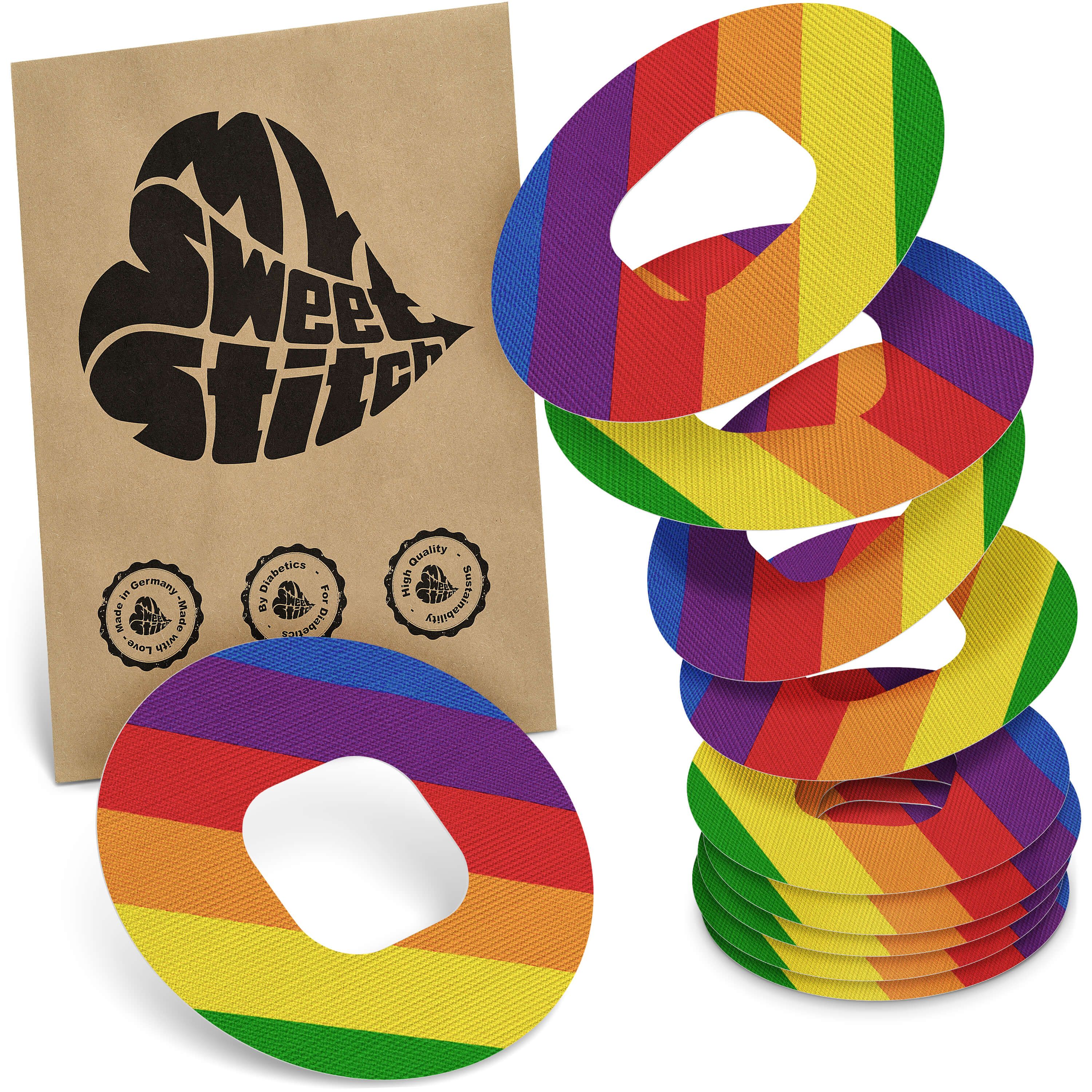 Mehrfarbige Ringpflaster mit Regenbogenmuster. Neben einer braunen Verpackung liegen mehrere Pflaster. Auf der Verpackung steht "My Sweet Stitch".