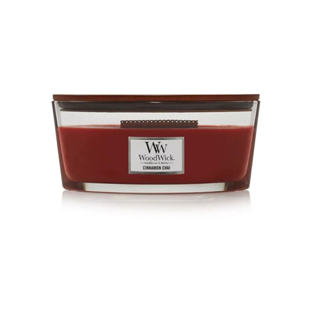 Ellipse-Kerze mit Holzdeckel. Roter Wachs in Glasbehälter. Label mit "WoodWick" und "Cinnamon Chai".