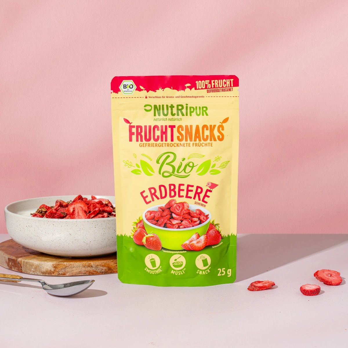 Beutel mit gefriergetrockneten Erdbeeren. Aufschrift: NutriPur, Bio, Frucht Snacks, 100% Frucht. Erdbeeren in Schale, Löffel.
