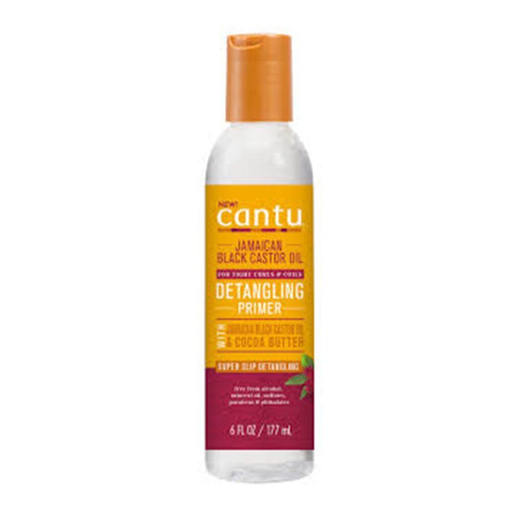 Flasche mit Cantu Jamaican Black Castor Oil Detangling Primer. Gelb-oranges Etikett, roter Boden. 6 fl oz / 177 ml.