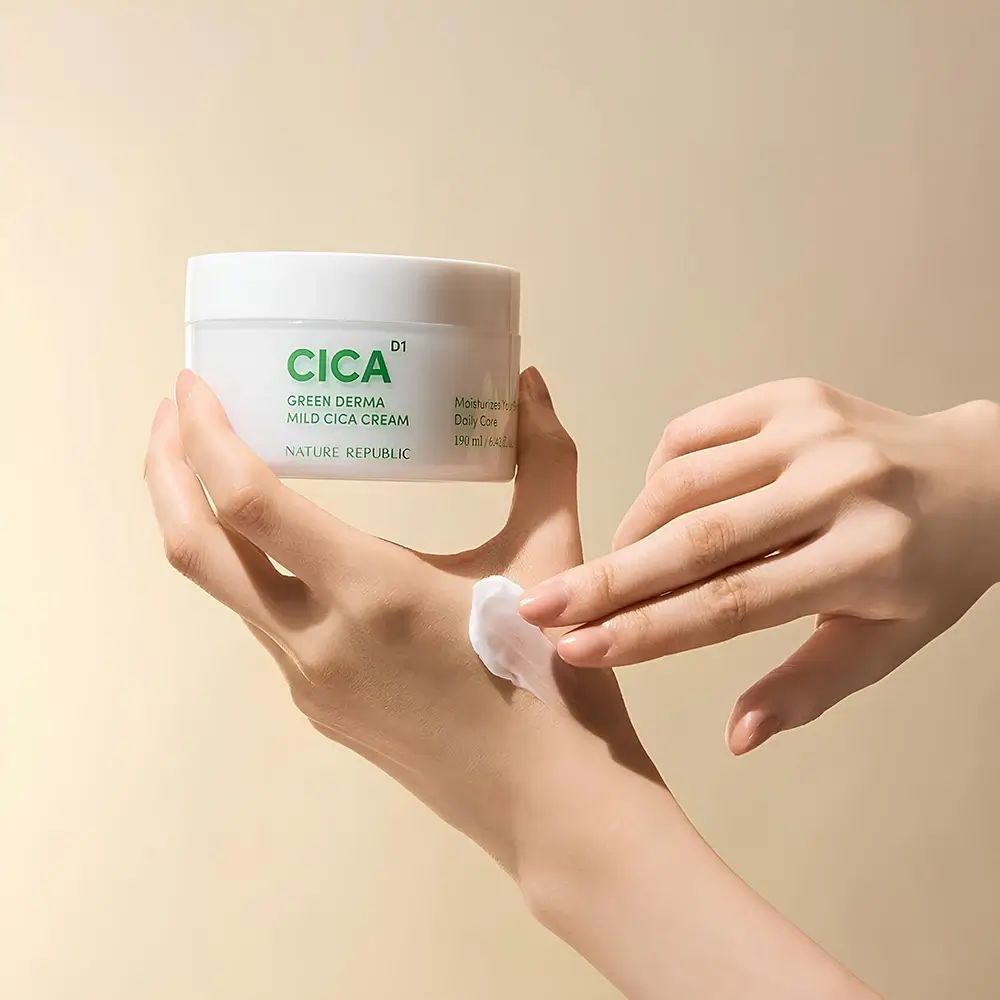 Hände tragen Creme auf. Weißer Tiegel mit grüner Aufschrift CICA, Green Derma Mild Cica Cream. Text: Moisturize dry areas.