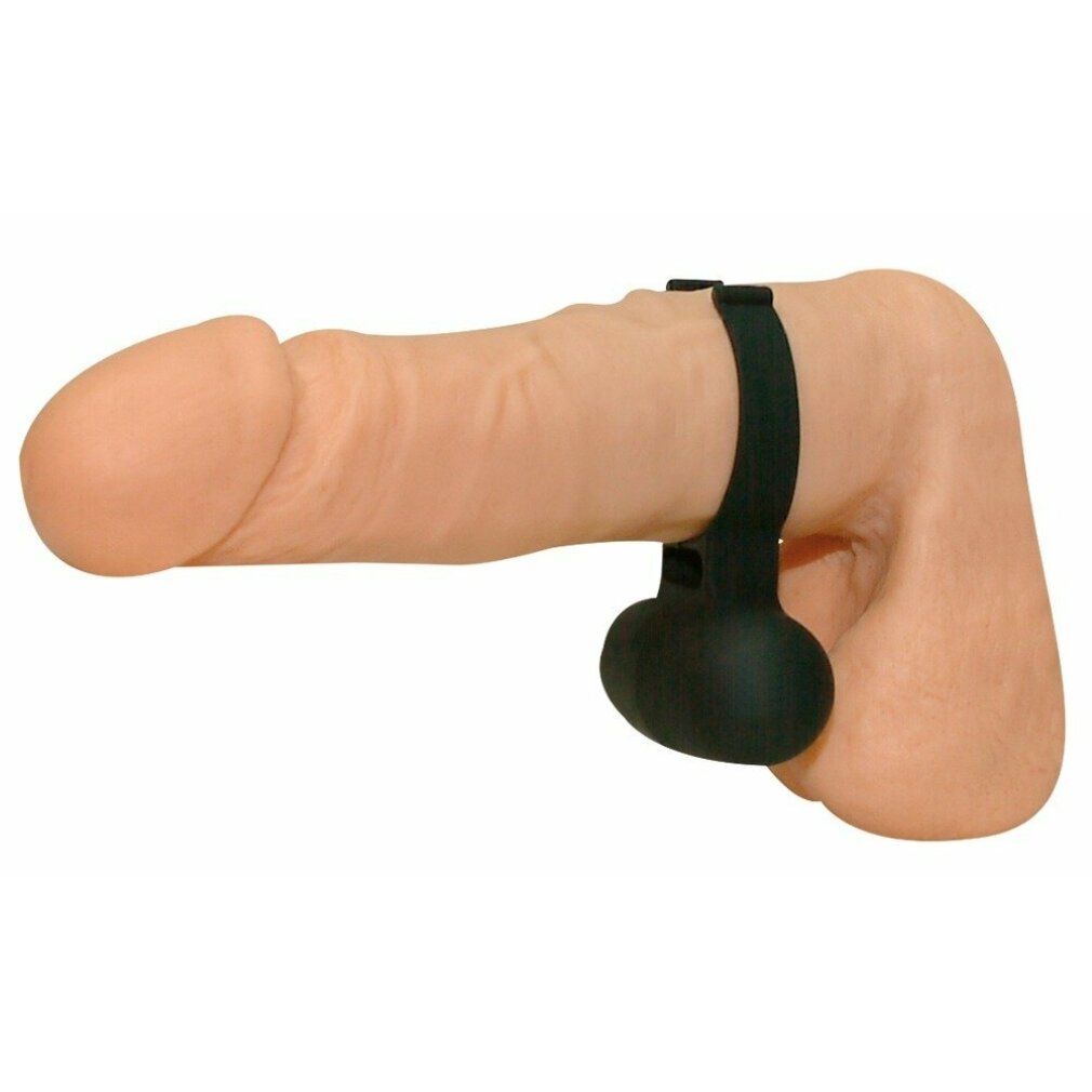 Schwarzer Cockring am Penis. Der Ring umschließt den Penis und den Hodensack.