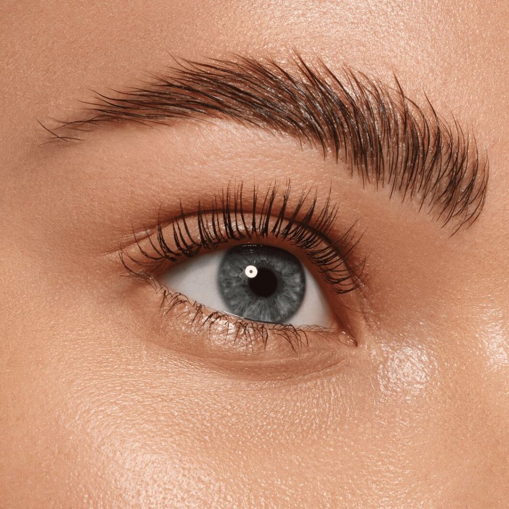 Nahaufnahme eines Auges mit betonten Augenbrauen. Die Augenbraue ist nach oben gebürstet und wirkt voller. Blaue Augen, helle Haut.