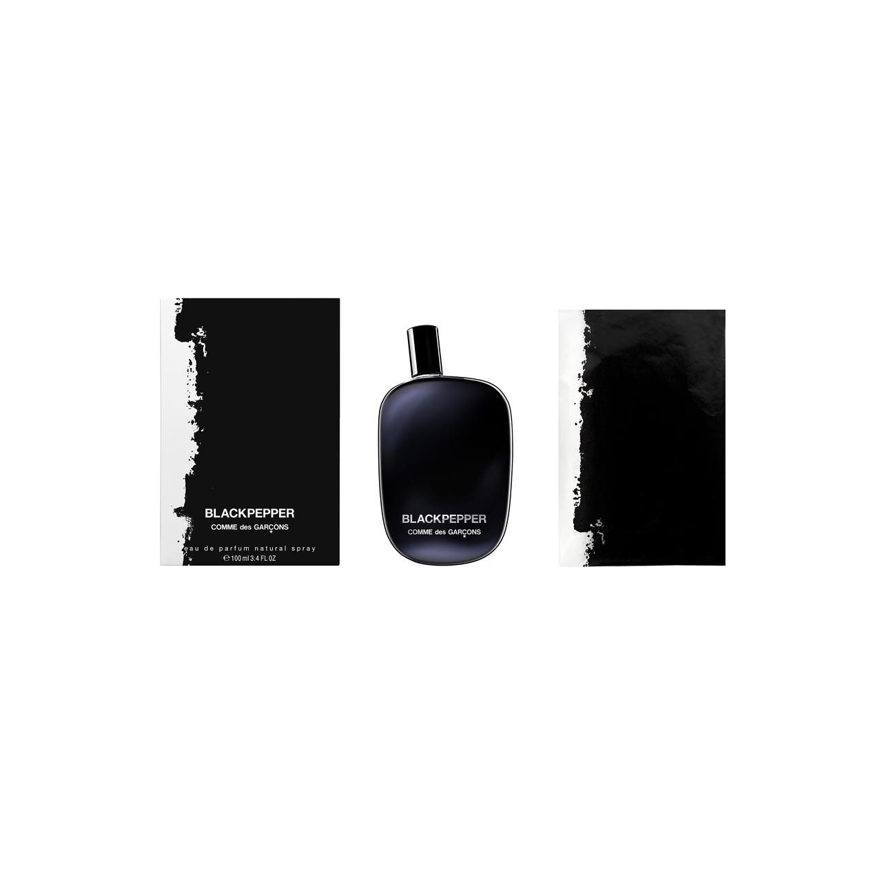 Schwarze Flasche, zwei schwarze Verpackungen. Aufschrift: Blackpepper, Comme des Garçons. Flasche steht zwischen Verpackungen.