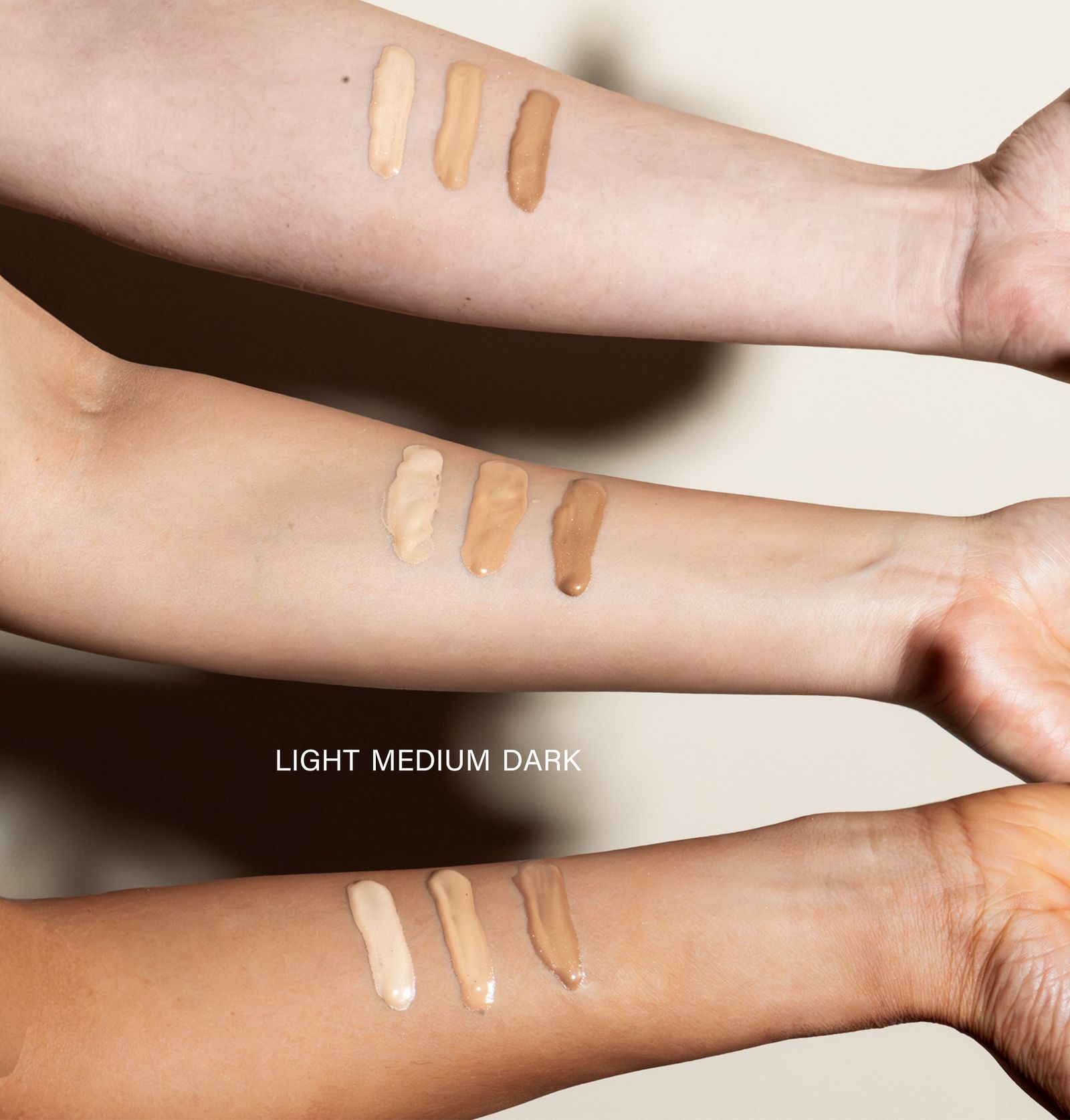 Drei Arme mit BB Serum-Proben. Markierungen: Light, Medium, Dark. Produkt-Farbtöne.