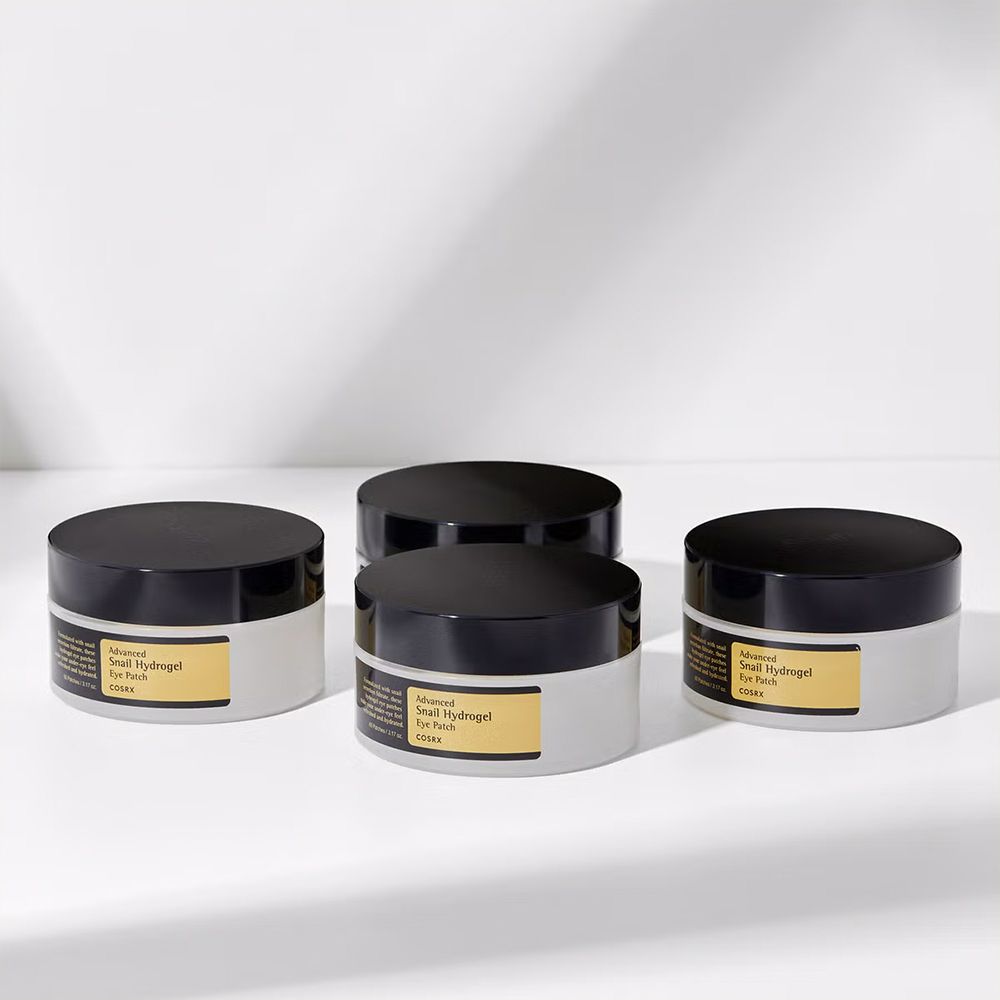 Vier Behälter mit Advanced Snail Hydrogel Eye Patch auf weißem Hintergrund.