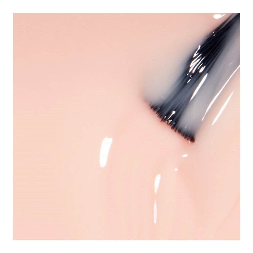 Nagellack-Applikator mit hellrosa Lack. Borsten in dunkler Farbe. Lack tropft.