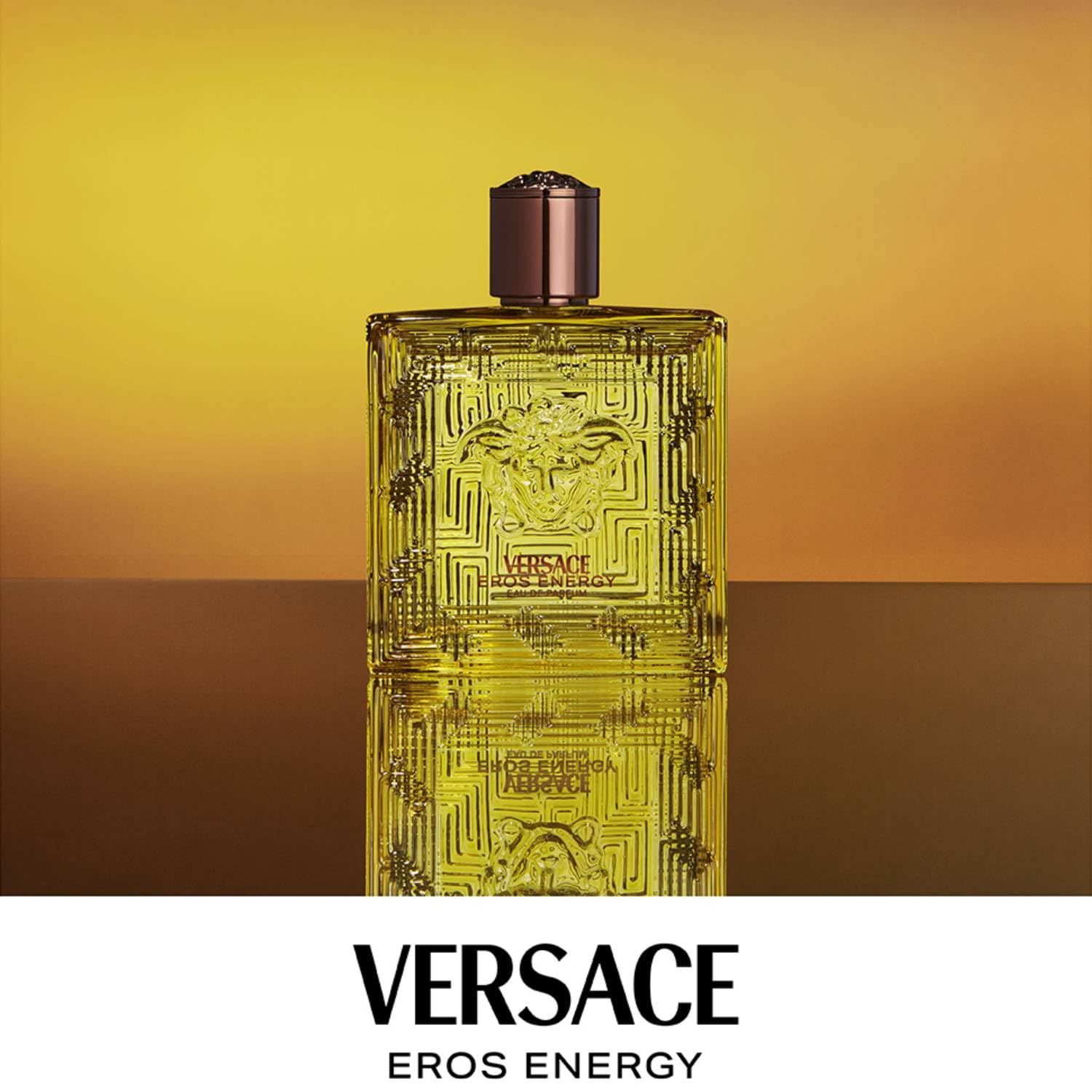 Versace Eros Energy EdP Flasche vor gelbem Hintergrund. Quadratische Form, Medusa-Logo. Markenname und Produktbezeichnung.
