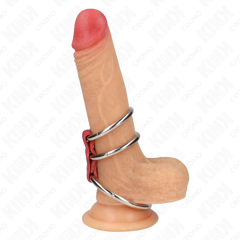 Penisring mit drei Metallringen und rotem Lederband. Der Ring ist an einem Dildo befestigt.