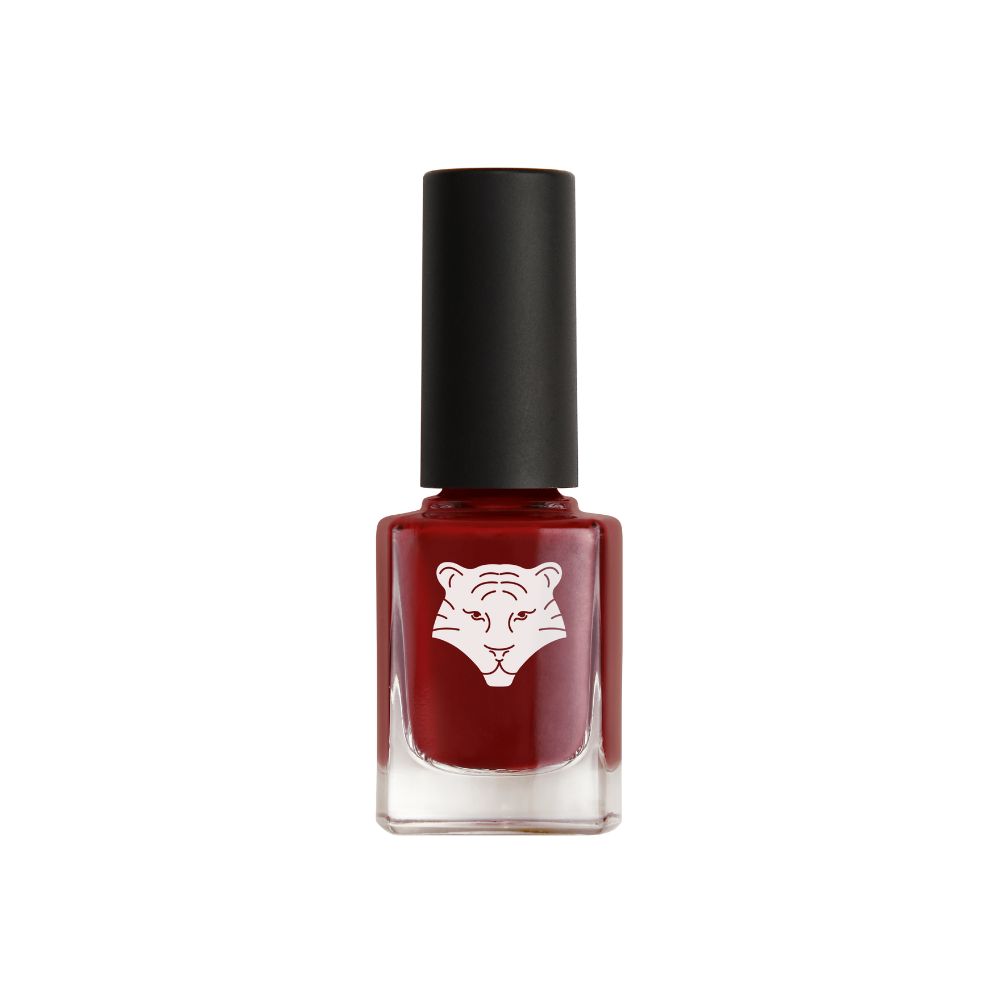 Nagellackflasche mit Tigerlogo. Roter Nagellack in einer quadratischen Glasflasche mit schwarzem Deckel.