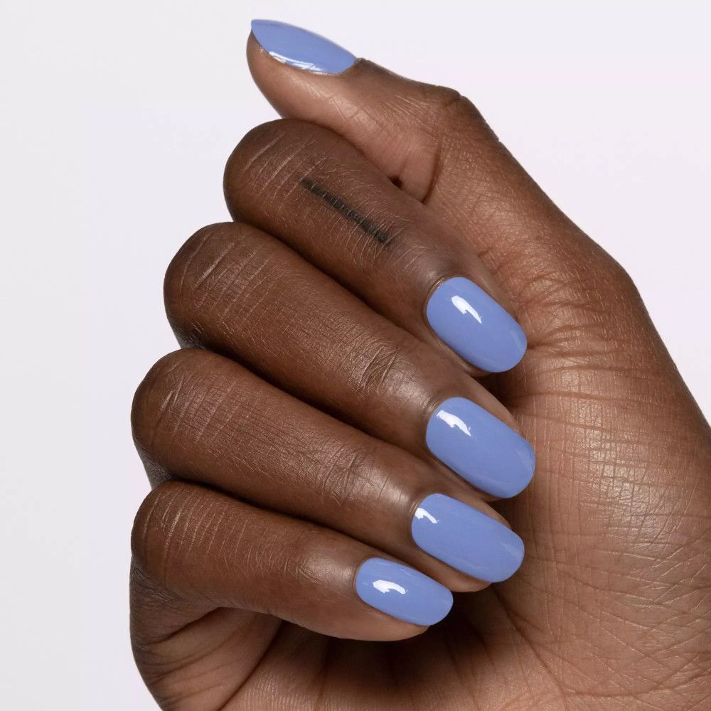 Hand mit lackierten Nägeln in hellblau. Oval geformt, glänzend. Auf hellem Hintergrund.