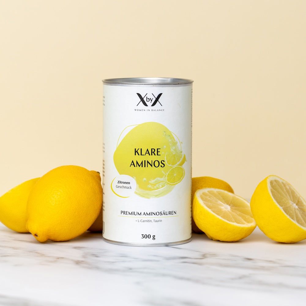Zylinderdose mit Produktetikett und Zitronen. Aufschrift: Klare Aminos, Premium Aminosäuren. Daneben Zitronen.