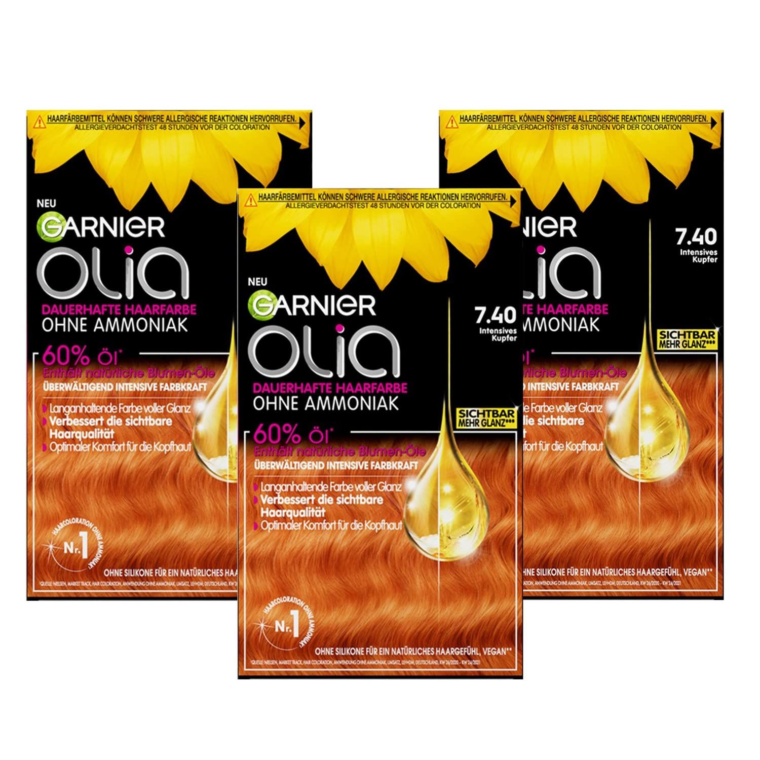 Drei Packungen Garnier Olia Haarfarbe. Schwarze Verpackung mit Sonnenblume, Produktname und Farbton 7.40 Kupfer.