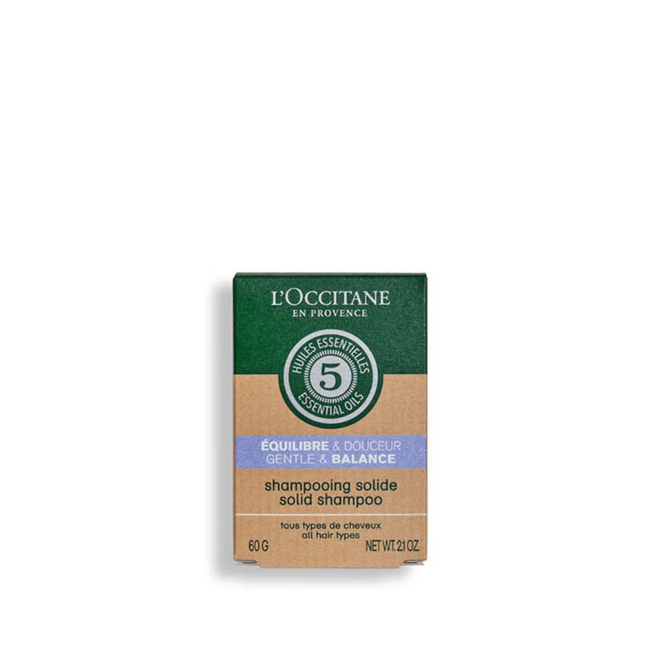 Kartonverpackung mit L'Occitane-Logo. Text: ÉQUILIBRE & DOUCEUR, SHAMPOOING SOLIDE. 60g, NET WT. 2.1OZ. Siegel: 5 Essential Oils.
