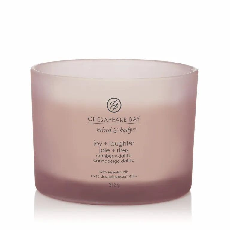 Rosafarbene Kerze mit drei Dochten. Aufschrift: Chesapeake Bay, mind & body, joy + laughter, joie + rires, cranberry dahlia, canneberge dahlia. Mit ätherischen Ölen.
