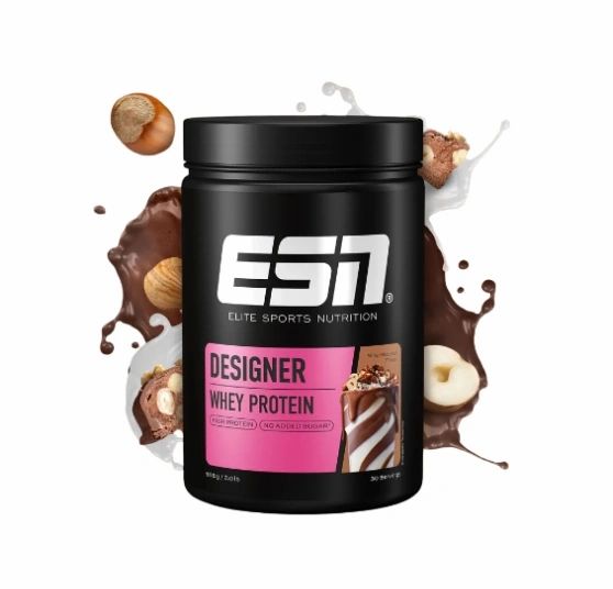 Schwarze Dose mit ESN-Logo und Produktbezeichnung Designer Whey Protein. Rosa Etikett mit Produktbild und Haselnüssen.