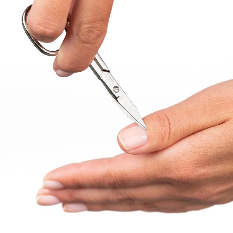 Nagelschere mit Turmspitze, silberfarben, in Anwendung. Schneidet einen Fingernagel.