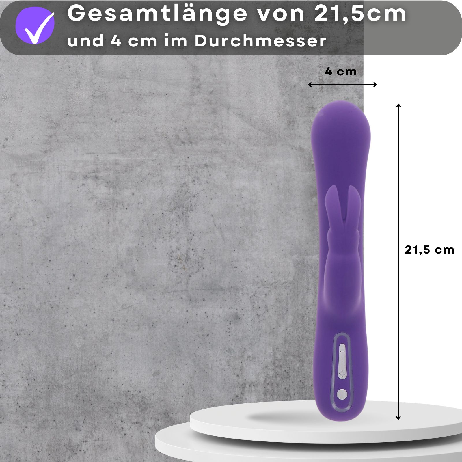 Lila Vibrator. 21,5 cm lang, 4 cm Durchmesser. Auf Podest. Grauer Hintergrund.
