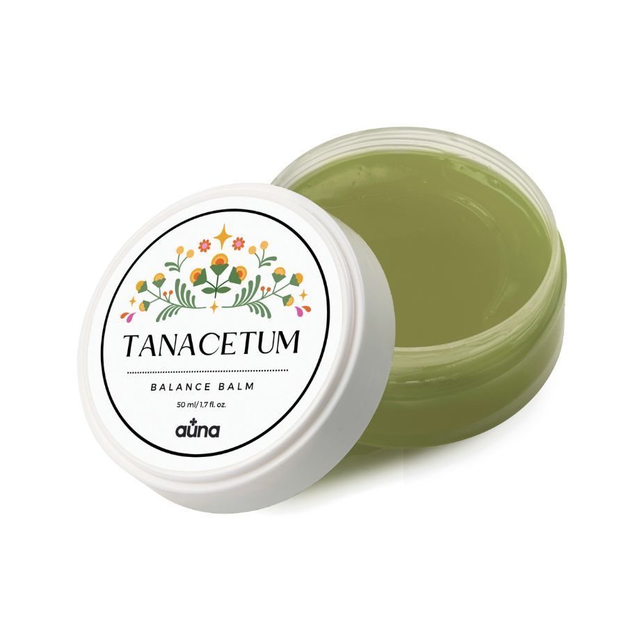 Geöffnete Dose mit grünlichem Balsam. Weißer Deckel mit floralem Etikett. Text: TANACETUM BALANCE BALM, auna.