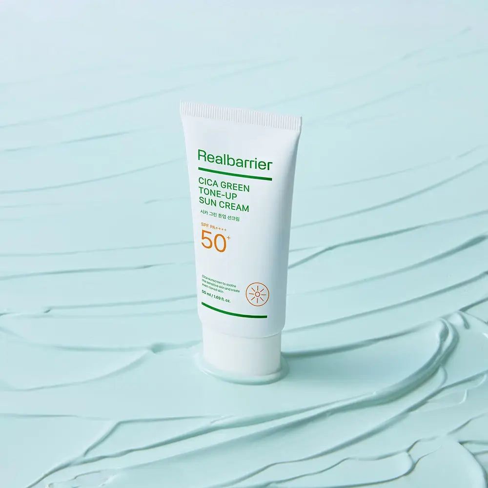 Eine Tube Real Barrier Cica Green Tone-Up Sun Cream, auf hellblauem Untergrund.