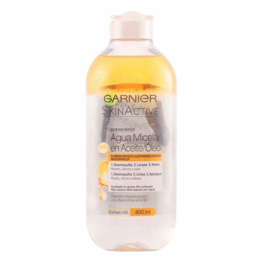 Klare Flasche mit gelber Flüssigkeit und weißem Deckel. Aufschrift Garnier SkinActive, Agua Micelar en Aceite/Óleo. 400 ml.