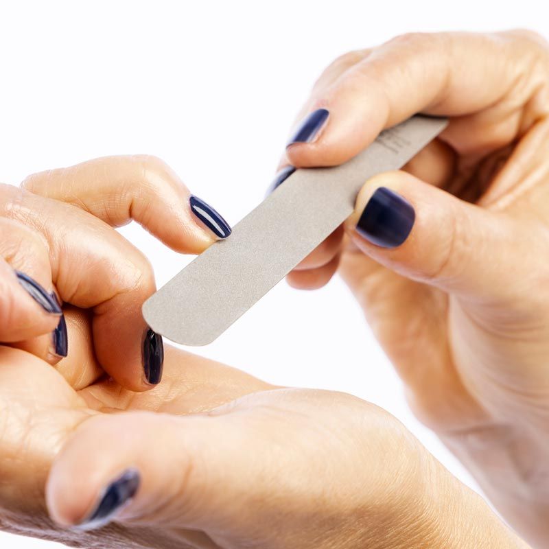 Hände feilen einen Nagel mit einer grauen Feile. Aufschrift: remos Diamond Nail File medium.