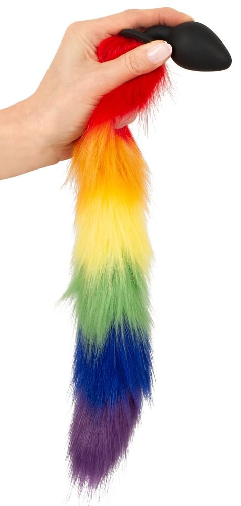 Hand hält einen Regenbogenfarbenen Fluffy Tail mit schwarzem Stecker.