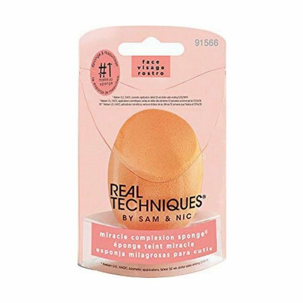 Verpackung mit einem orangefarbenen Make-up-Schwamm. Auf der Verpackung steht 'REAL TECHNIQUES' und 'MIRACLE COMPLEXION SPONGE'.