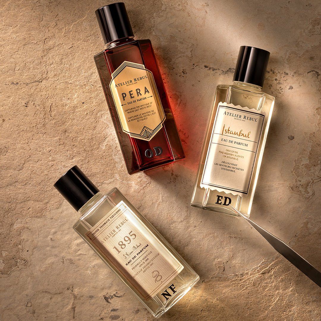Drei Parfümflakons. Schwarze Kappen. Aufschrift: Atelier Rebul. Verschiedene Düfte: Pera, Istanbul, 1895 Eau de Parfum. Auf Steinplatte.