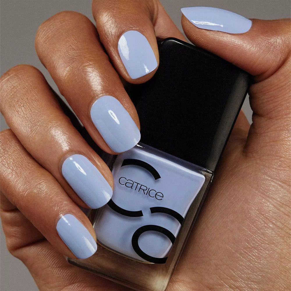 Hand mit lackierten Nägeln und Nagellackflasche. Auf der Flasche steht Catrice.