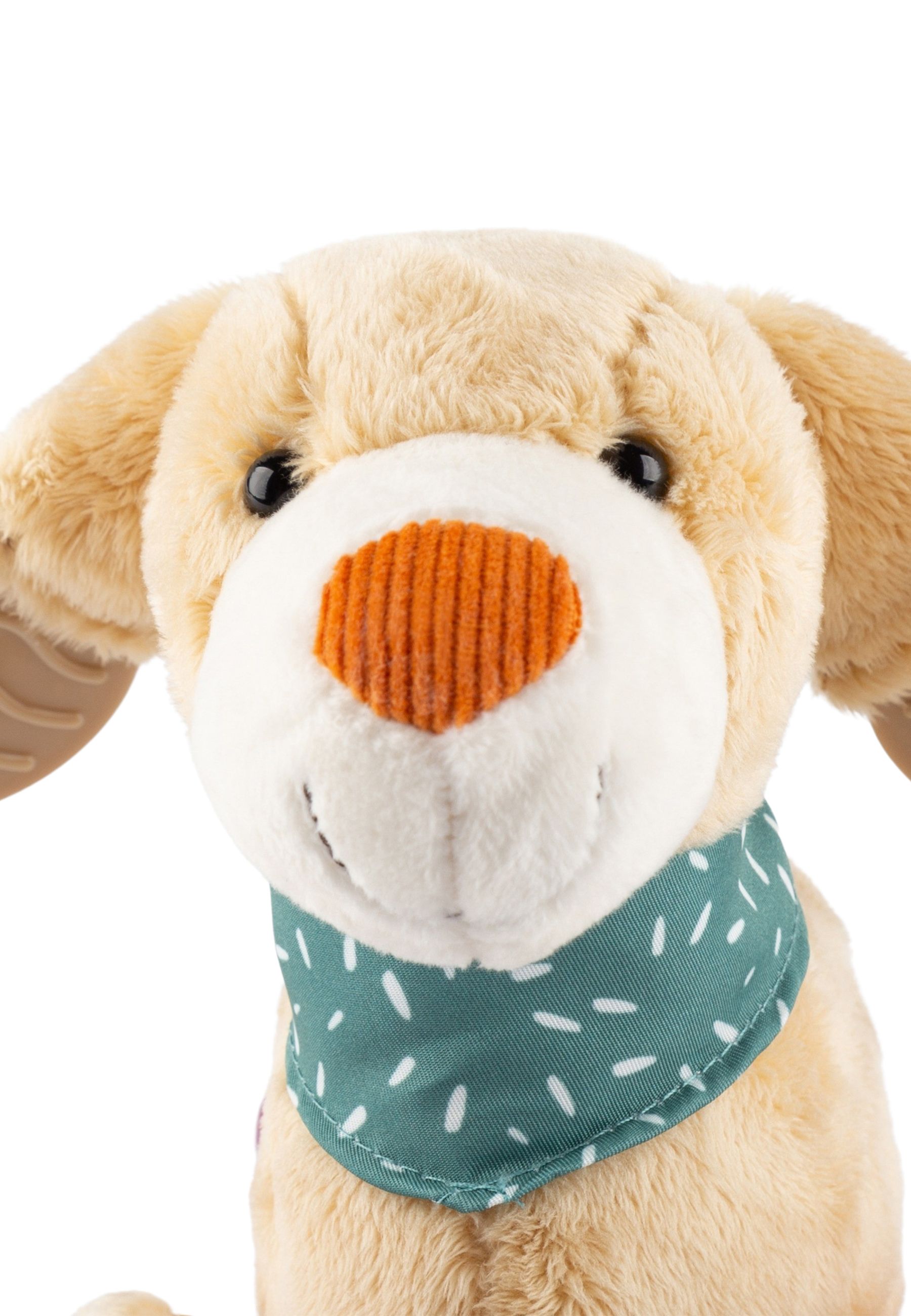 Nahaufnahme eines beigefarbenen Stoffhundes mit orangefarbener Nase und grünem Halstuch mit weißen Punkten.