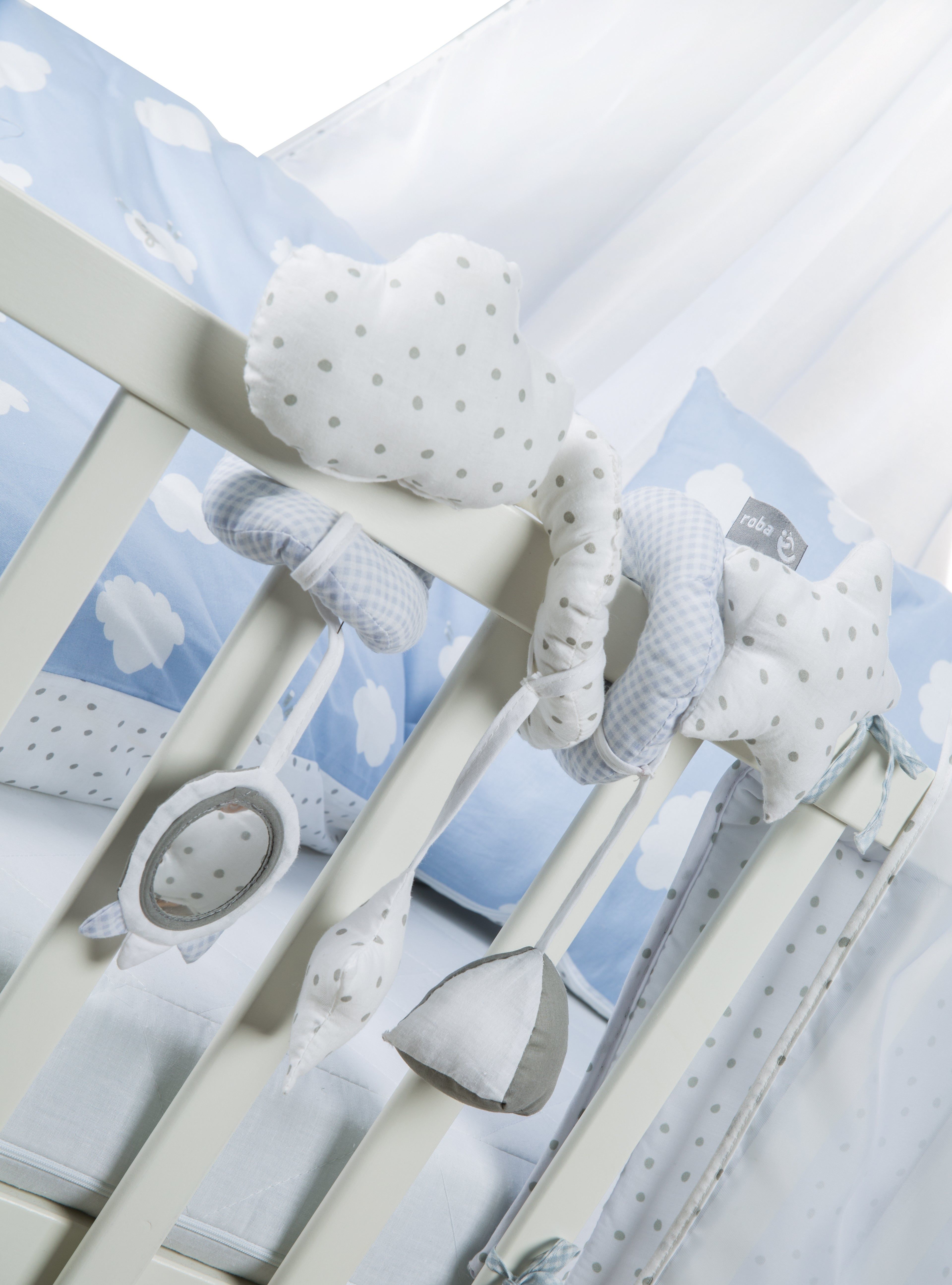 Aktivitätsspirale mit Wolken- und Sternmotiven. Hängeelemente: Spiegel, Stern, Glocke. Weiß-grau-blau. Am Kinderbett befestigt.