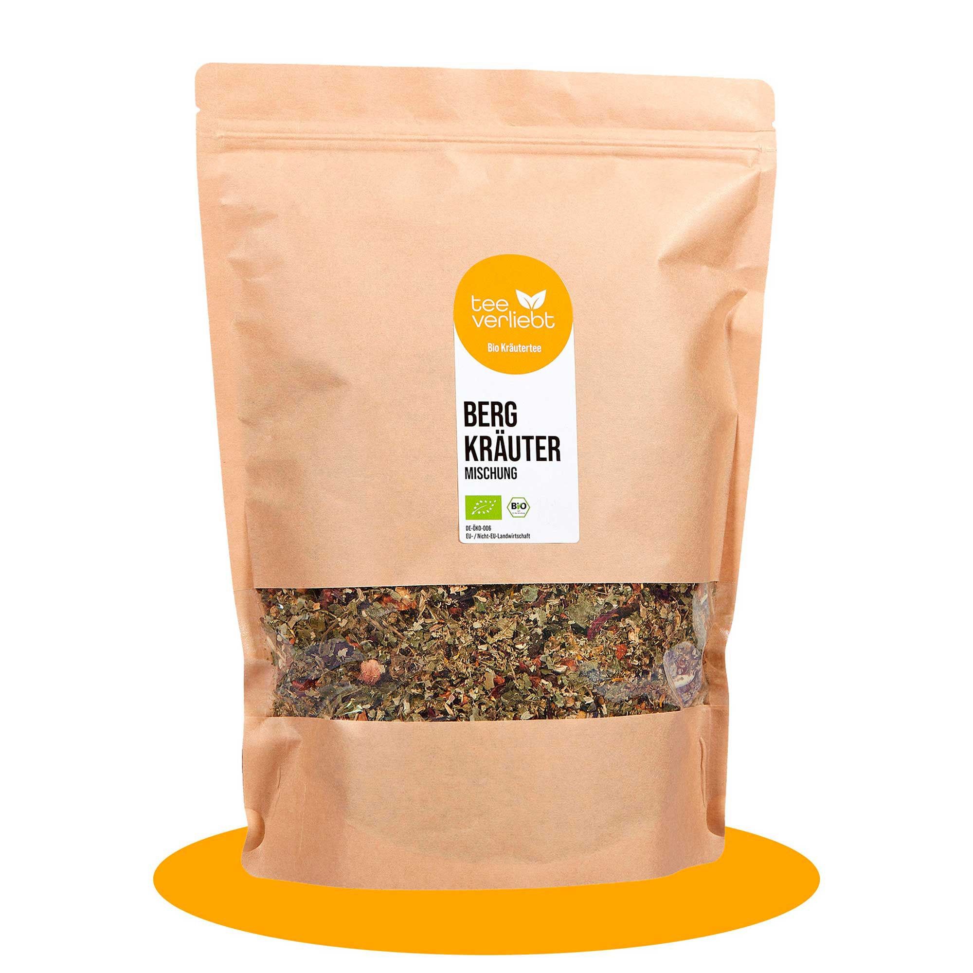 Beutel mit Bergkräuter-Mischung. Sichtfenster zeigt Kräuter. Logo und Text auf Etikett: "tee verliebt", "Bergkräuter Mischung", Bio-Siegel.
