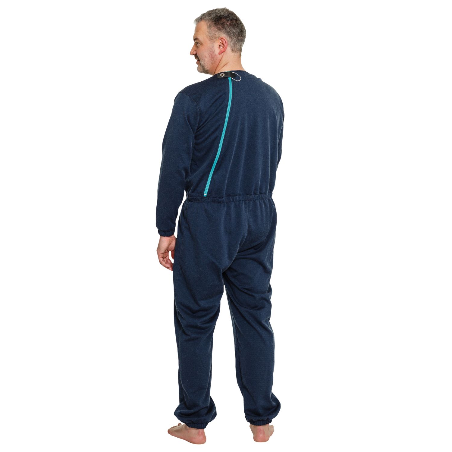 Blauer Pflegeoverall mit Reißverschluss am Rücken. Sicherheitsknopf am Kragen. Manschetten an Armen und Beinen.