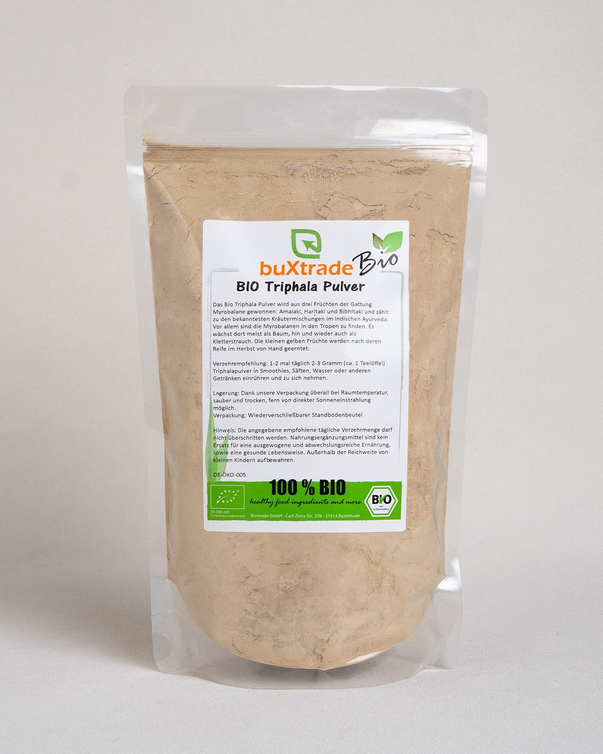 Transparente Plastiktüte mit buXtrade Bio Triphala Pulver. Etikett mit Produktinformationen und Bio-Siegel.